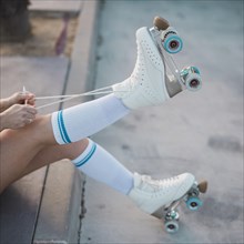 Low section woman tying lace roller skate road