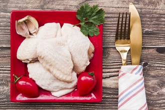 Uncooked meat ingredients plate with golden fork butter knife