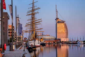 Sail training ship Germany in the New Harbour with the Atlantic Sail City Hotel in the evening sun