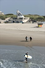 Surfers leaving the water and walking to the O'Neill Beach club in Blankenberge