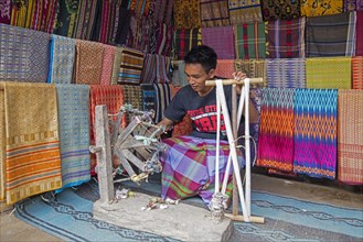 Indonesian weaver weaving traditional songket fabrics on primitive wooden loom in the Sasak village Sade on the island Lombok
