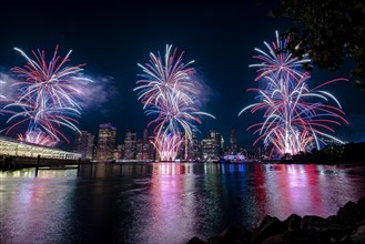 Independence day celebration in New York City with Macy's Fireworks in Lower Manhattan on East River and Brooklyn Bridge