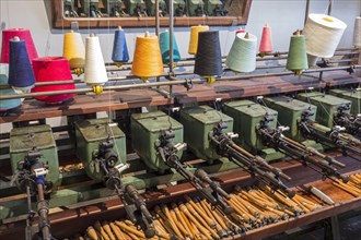 Colourful bobbins with yarns on spool machine in cotton mill