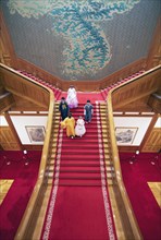 Visitors in traditional dress on the red staircase in the Blue House or Cheongwadae