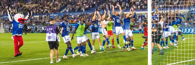 Racing Strasbourg players celebrate the victory over Olimpique Lyon in the fan curve
