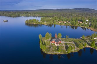 Aerial view over the red wooden Raemmens kyrka