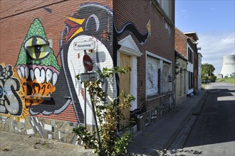 The desolate Flemish polder village Doel along the Antwerp port with abandoned houses covered in graffiti by squatters