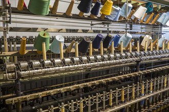 Colourful bobbins with yarns on twisting frame in cotton mill