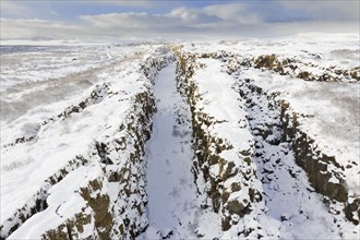 Aerial view over the Almannagja Canyon in the snow in winter