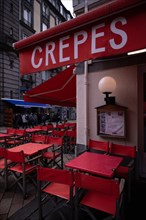 Advertising for crepes at Cafe de la Place in the rain