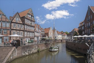 Historic merchant and warehouse houses at the Hanseatic harbour with the sailing ship Willi