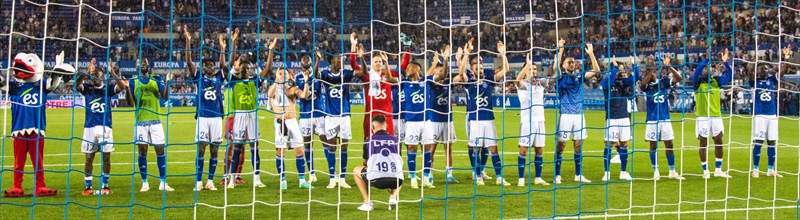 Racing Strasbourg players celebrate the victory over Olimpique Lyon in the fan curve