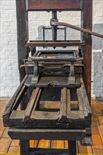 18th century wooden hand press with metal screw for relief printing