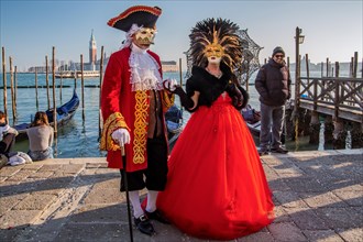 Carnival masks on the waterfront with San Giorgio Island at the time of Carnival
