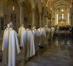 Priests in solemn vestments enter the Cathedral di San Cerbone for Mass on Holy Thursday