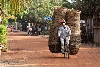 Man transporting many baskets on bicycle