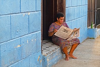 Cuban woman reading the Trabajadores