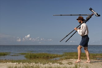 Birdwatcher with spotting scope on the island of Minsener Oog