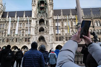 A tourist uses a phone while in Marienplatz to watch the Glockenspiel in the new town hall. Marienplatz