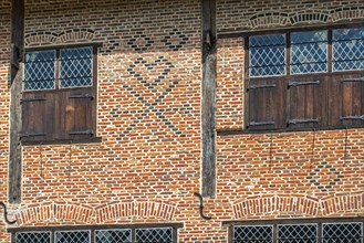 Flemish mason's symbols in brickwork on facade of 16th century brick house showing checks