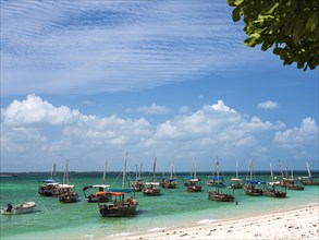 Boats on the white beach in the turquoise sea