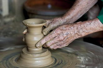 Old hands making pottery