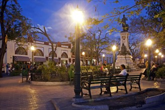 Tourists at colonial square in the evening at Santiago de Cuba