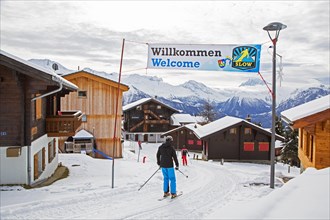 Skiers entering the Swiss traffic-free village Riederalp in the snow in winter
