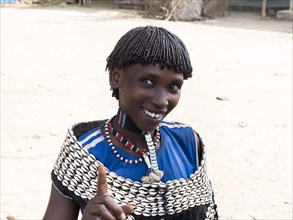 Laughing woman with shell jewellery from the Tsamay tribe
