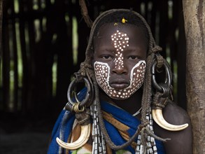 Boy of the Mursi tribe with headdress and face painting