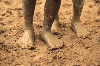 Children's legs in clay soil