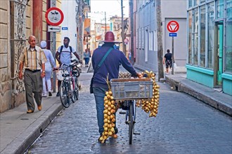 Cuban street vendor with bicycle selling onions in the old town centre of the city Camagueey on the island Cuba
