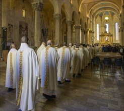 Priests in solemn vestments enter the Cathedral di San Cerbone for Mass on Holy Thursday