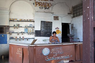 Shopkeeper behind counter of Cuban state shop in Cienfuegos