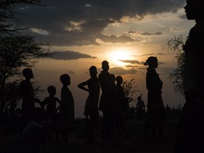People of the Hamar tribe against the light in the evening