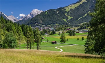 Landscape on the high plateau with a view of the village and the northern Karwendel mountain range