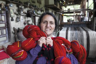 Indian woman with weaving yarn in weaving mill