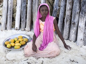 Local girl selling mangoes on the beach