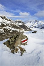 Characteristic white and red stripes on rock marking a GR long-distance footpath in the Swiss Alps at Wallis