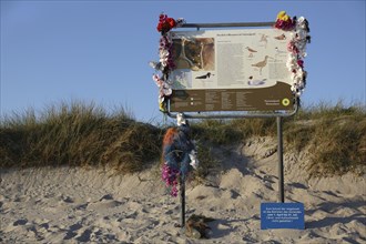Tourist information board decorated with marine litter on the island of Minsener Oog