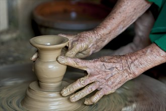 Old hands making pottery