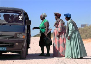 Herero woman in front of a shared taxi