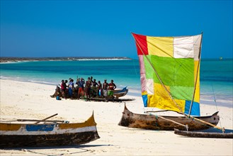 Outrigger boat with colourful sail on the beach