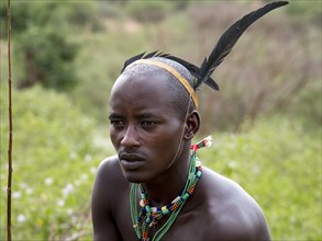 Young man from the Hamar tribe with feather headdress