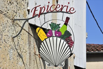 Signboard at grocery shop showing scallop symbol along the road to Santiago de Compostela at La Romieu