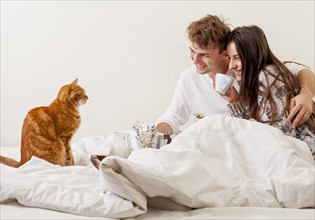 Young couple having breakfast bed