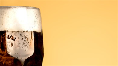 Cold glass beer yellow background