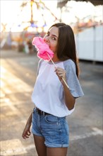 Mid shot woman eating pink cotton candy