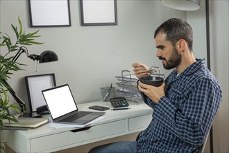 Man having breakfast while working from home