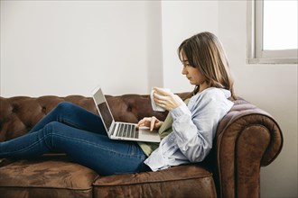 Woman lounging with coffee laptop